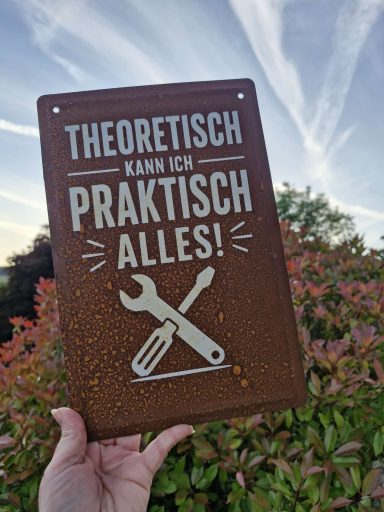 Rostige Schilder Metallschild mit der Aufschrift "Theoretisch kann ich praktisch alles!" und Werkzeugmotiven.