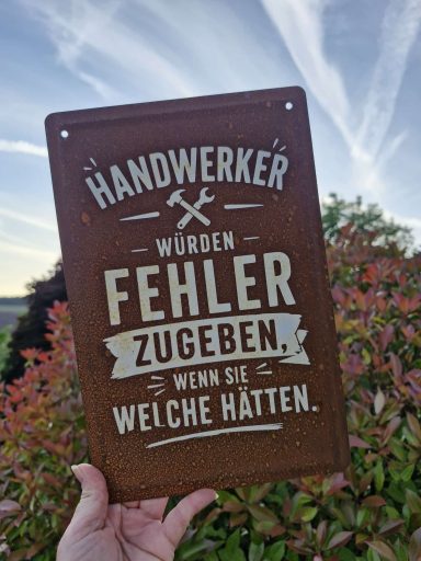 Schild mit dem Text: „Handwerker werden Fehler zugeben, wenn sie welche hätten.“
